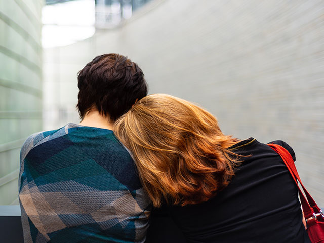 2 young people comforting each other